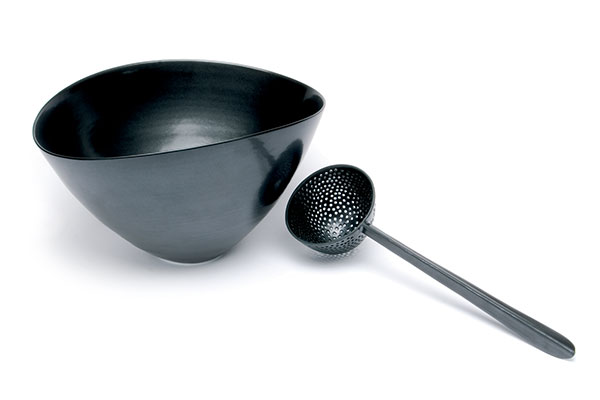 1 Prue Venables’ black bowl and pierced ladle, to 11¾ in. (30 cm) in width, Limoges porcelain, wheel thrown and altered, 2005. Photo: Terence Bogue.