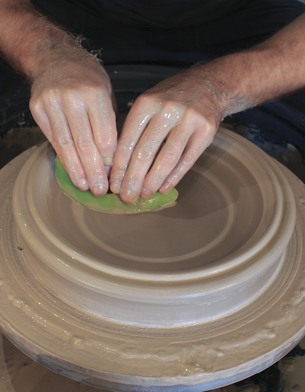 8 Slow the wheel and use a medium-hard rib to define the curve of the bowl.