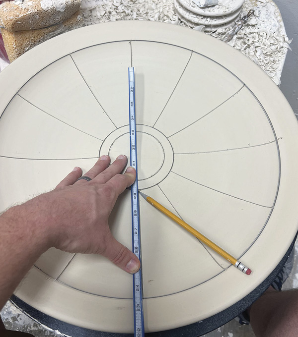 1 Once leather hard, use a laser, straight edge, and pencil to divide the platter into even segments.