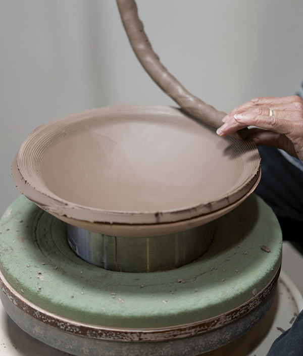 2 Add a coil to the scored and slipped slab. When adding coils use your thumb to bring the outside clay up over the coil.