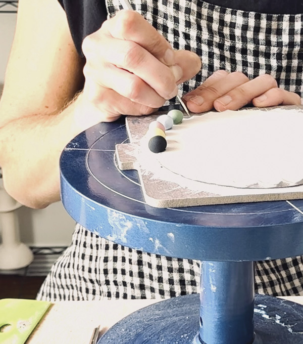 6 Score and slip each dry underglazed ball onto the platter’s rim. Alternate various colors for a more festive look.