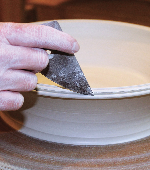 1 Throw a plate with high sides and a thick rim. Split the rim with the rounded, pointy end of a wooden rib.