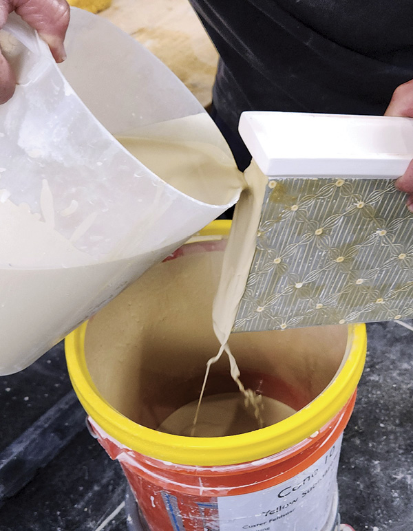 14 Holding the vase over the glaze bucket, pour glaze over the sides.