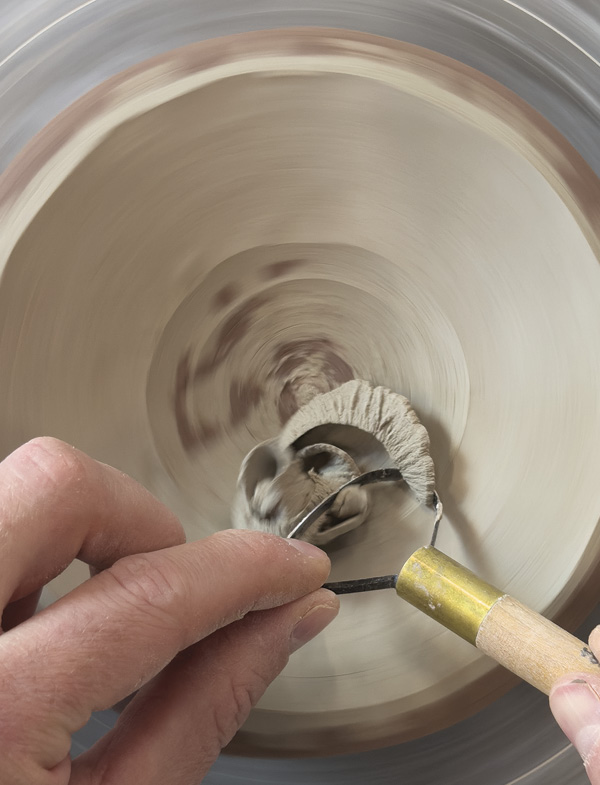 6 With the wheel spinning, trim the clay away to reveal the inlaid design.