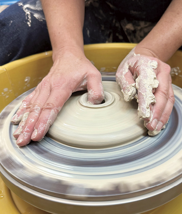 1 Center 1 1/2 pounds (0.7 kg) of clay low and flat as if throwing a plate, and open all the way to the wheel head.