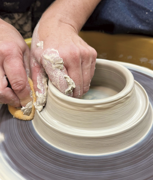 3 Continue to collar the vase up, further forming the cone. Use a sponge on the exterior to facilitate easy throwing.