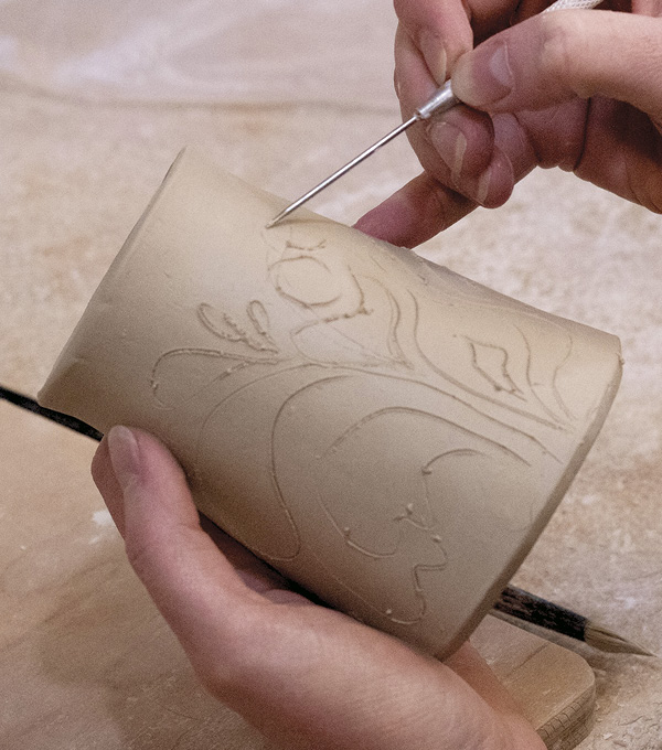 1 On a double-walled form, sketch a pattern. Loose, wavelike lines emerge from the base and stretch around the cup.