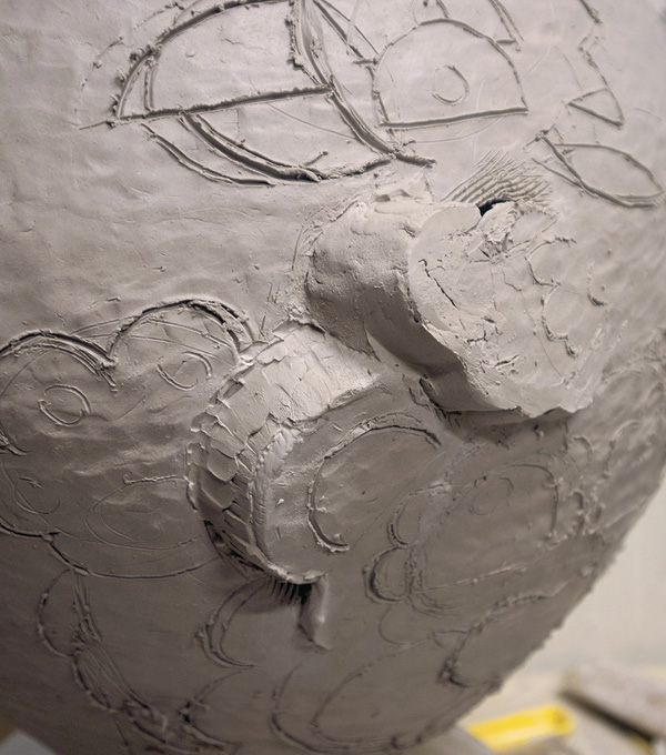 4 Close the open spaces with coils and slabs, and add clay to the remaining drawn lines to make them high relief.