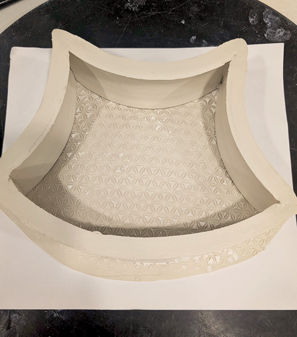 4 Slump a slab, textured-side down, onto the frame. Gently press in the middle to make it concave, let it firm up, then flip.