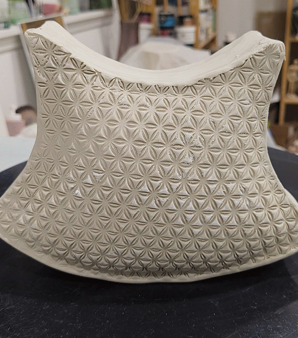 6 Attach one slab to the frame, texture side out. Repeat with the other slab to close the form. Add feet and a handle.