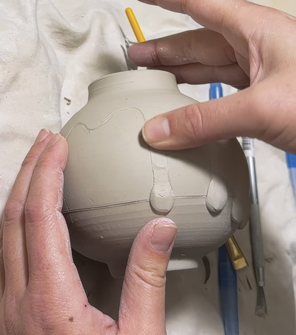 2 Add small clay balls to the lower sections of the drip design. Do this before you do any cutting.