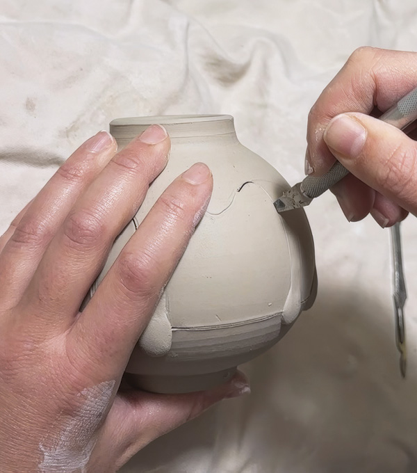 3 Cut along the marked lines. Leave the cut segments in the pot for support while you make the rest of the incisions.