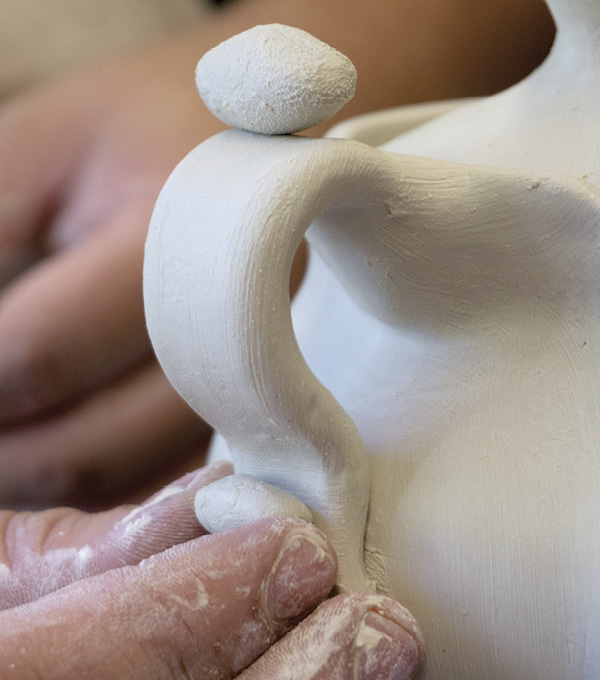 5 Pull a handle, attach it, and refine it through further pulling. Allow it to set up, then shape it into an S-curve.