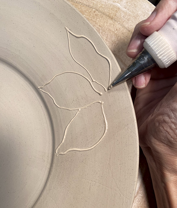 15 Allow the slip to trail behind you. Do not gouge the clay with the piping tip.