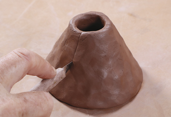 7 Make an open-ended, straight-walled pinch pot. Cut a vertical line through it.