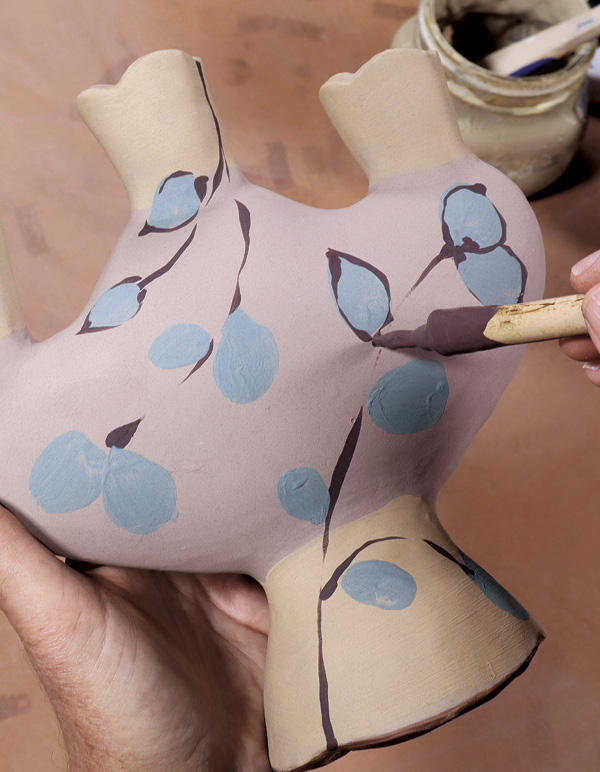 16 After the white slip dries, decorate with layers of colored slips.