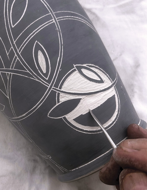 7 Lay a blade-shaped tool flat against pot, use the point to remove terra sigillata.