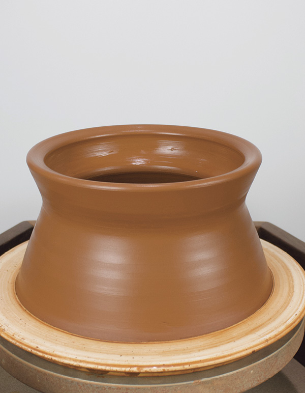 1 Throw a bottomless cylinder leaving a thick band of clay at the narrowest spot.