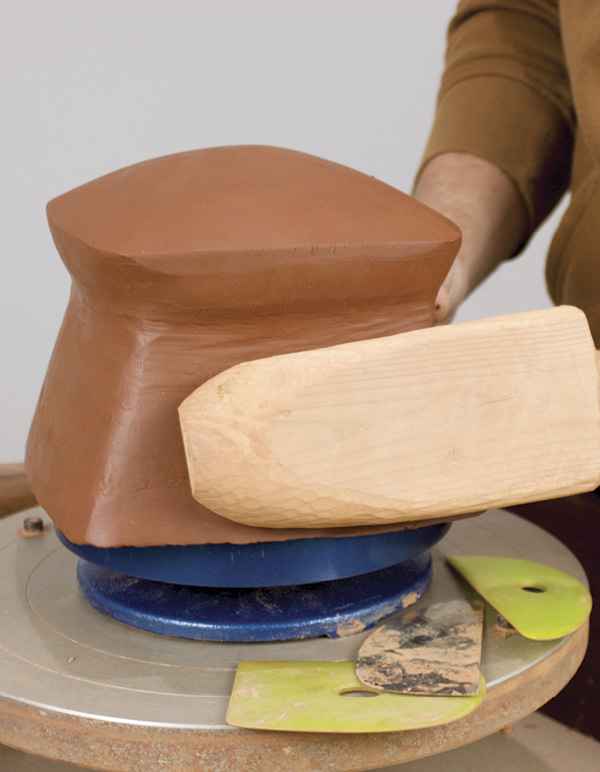 9 A wooden paddle and hard ribs are used to refine the shape.