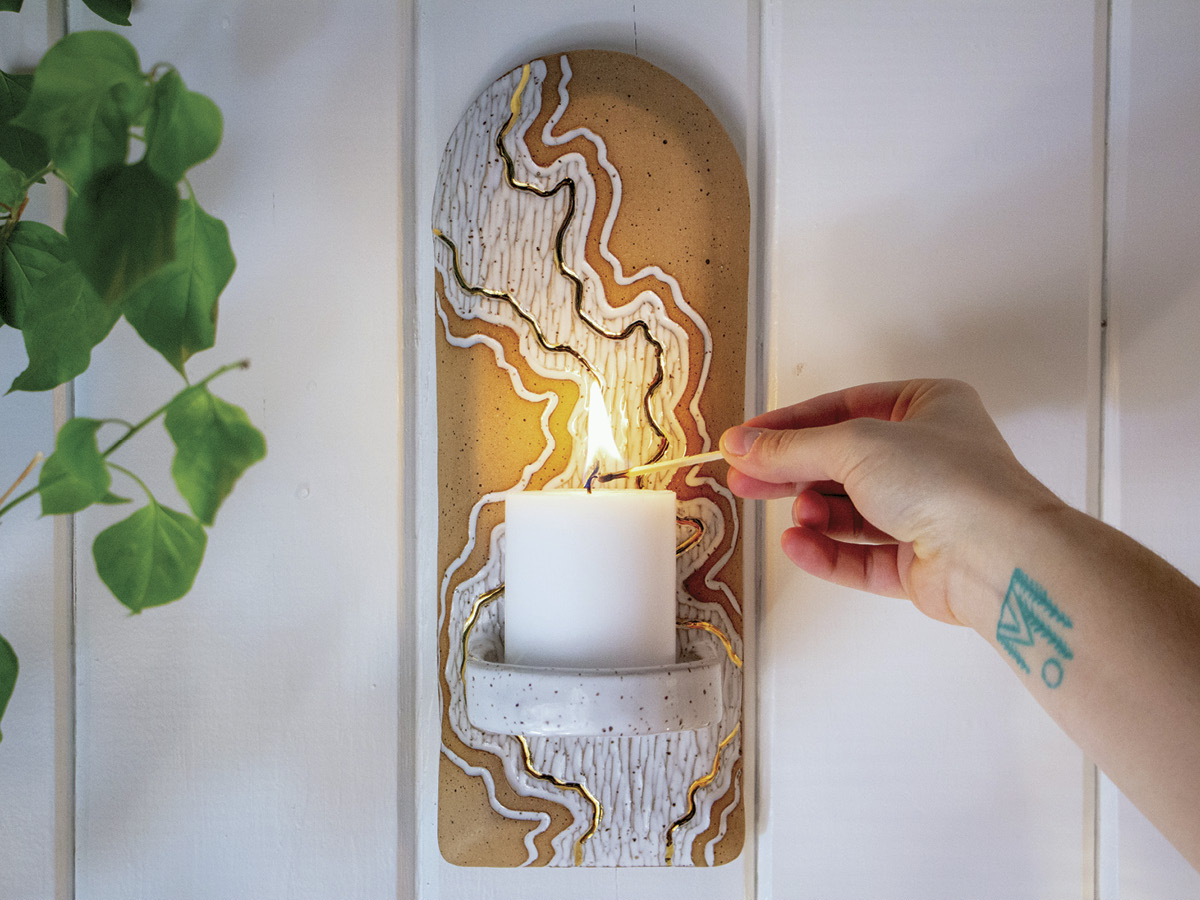 Jamin Bultman’s ceramic sconce hangs as a piece of art on your wall by day and warms up the room with cozy candle light at night.