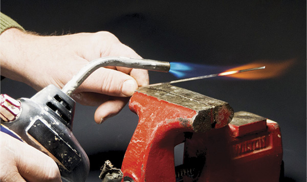 2 Hold the wire with a plier and heat the sharpened area until red hot with a small propane torch.