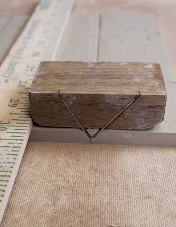 6 Use a double-beveled tool to create a folding corner joint on the layout lines.