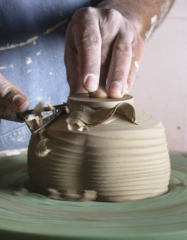 11 Trim the bulk of clay off the bottom and create the exterior of the foot ring.