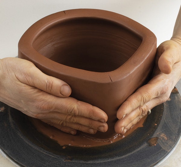 Example of using hands as a tool in forming clay.