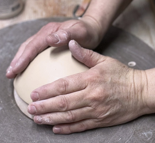 Example of using hands as a tool in forming clay.