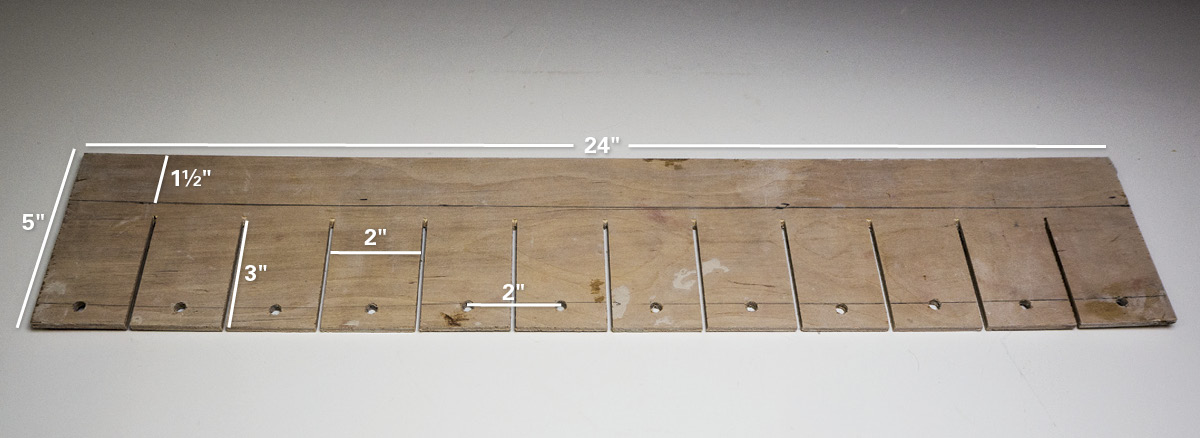 2 Plywood template with wood slits and drilled holes to aid in marking a clay slab to make individual test tiles.