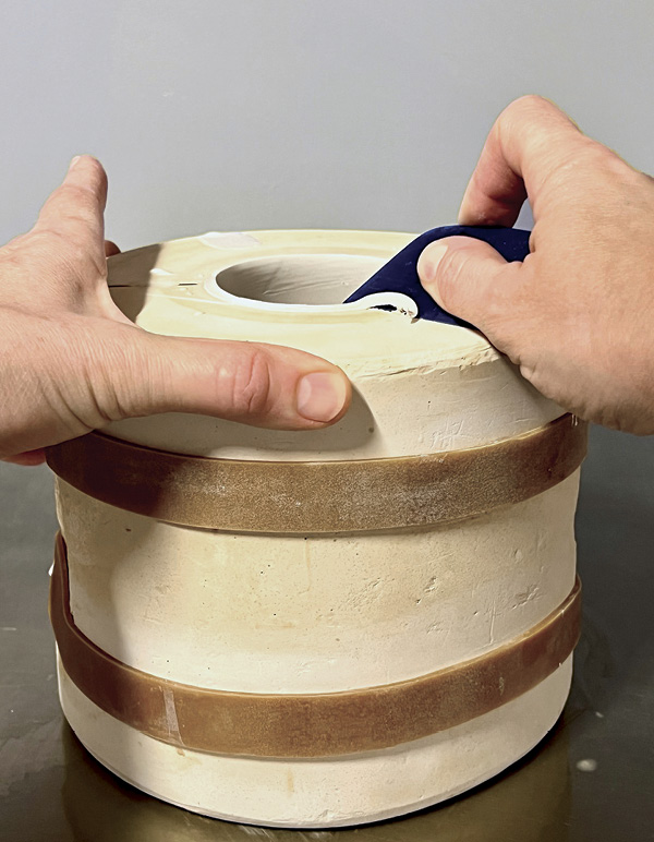 2 Cut the excess slip from the rim using a rigid plastic tool.