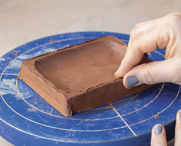 2 Use your fingers and a metal rib to refine the hollowed center and cut edges.