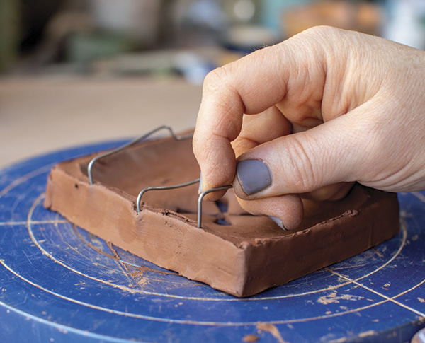 6 Insert the ends of the wires into the edges of the clay dish.