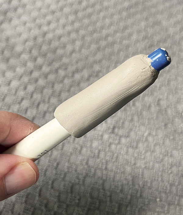 3 Press a small piece of clay around a dowel and smooth it with your finger. Wrap it in plastic.