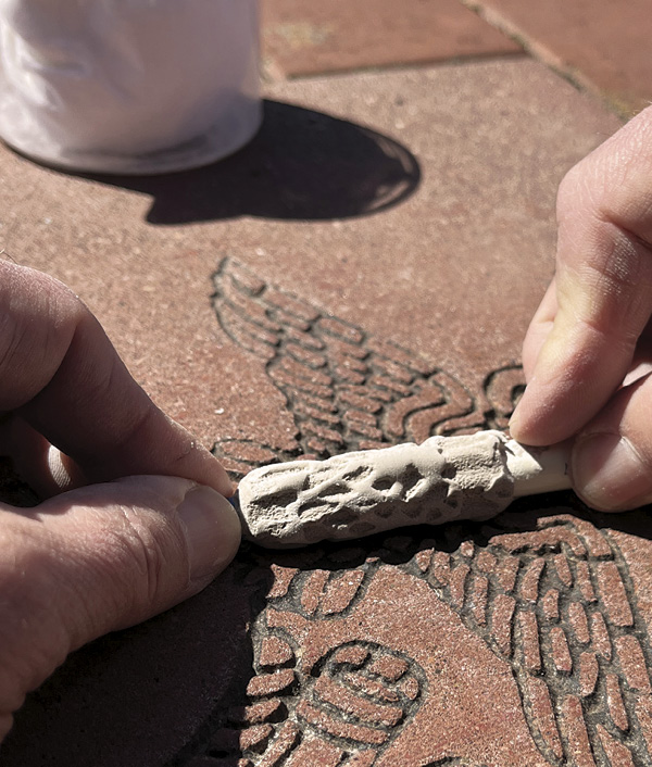 6 Press the clay-covered brush handle into the texture. Continue to lift, rotate, and press until covered with texture.