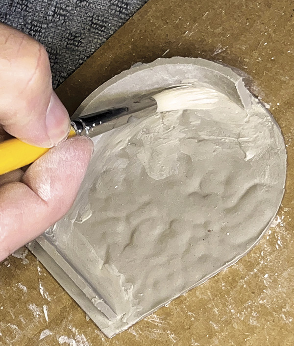 13 Press the base onto the front panel. Repeat process to attach sides. Clean joints with soft brush.