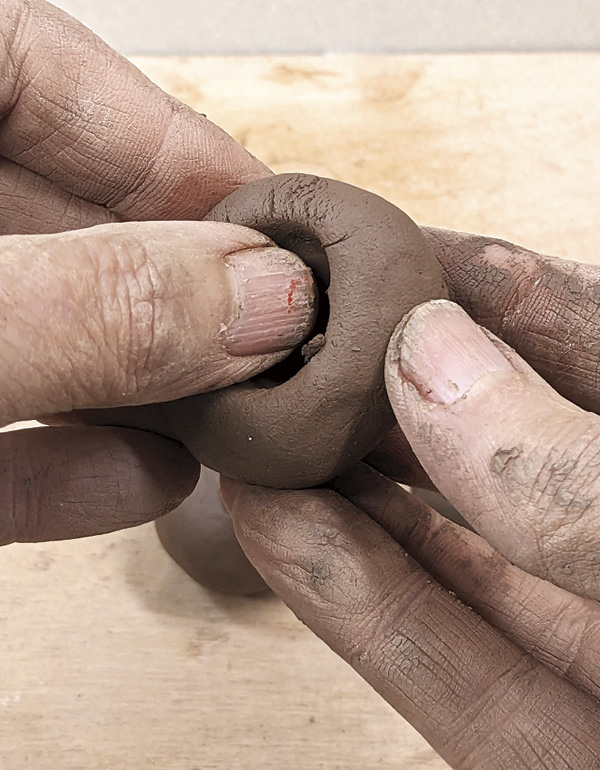 9 Make three solid balls of clay, then pinch out the cups.