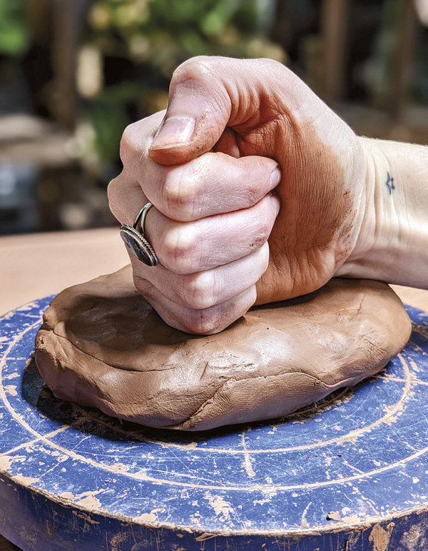 1 Compress the clay with your fist. Press the outer edge down with your thumb.