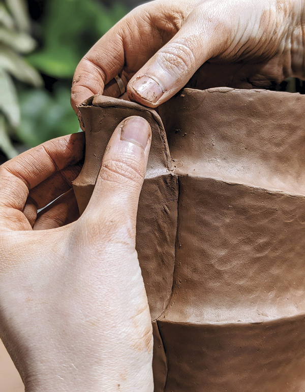 14 To enclose the spout, pinch a slab into its rim, leaving a rounded opening.