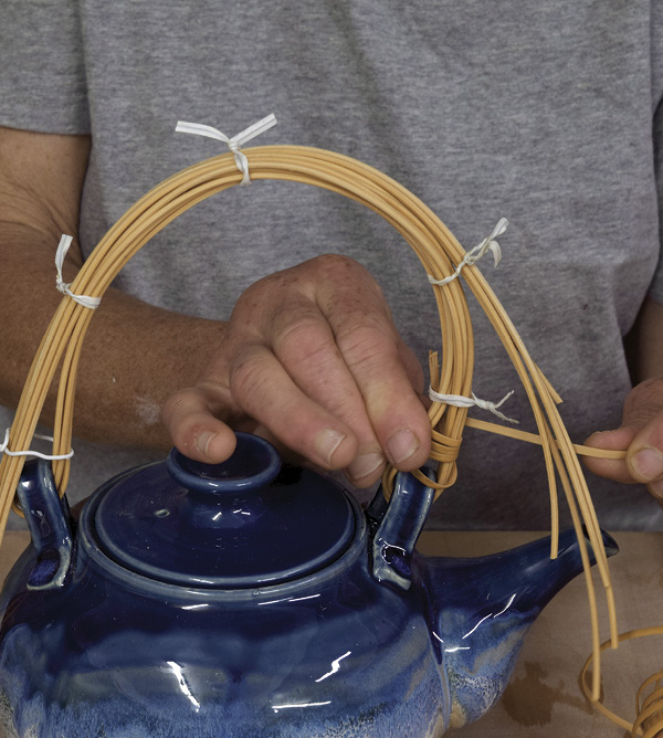 4 Put the end of the binder cane up the inside of the handle, under the first twist tie.