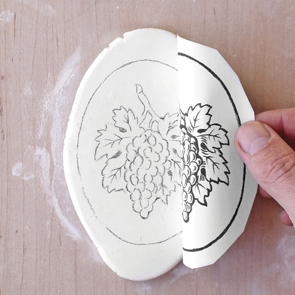 3 Trace the drawing in reverse. Transfer it by pressing the paper onto wet clay.