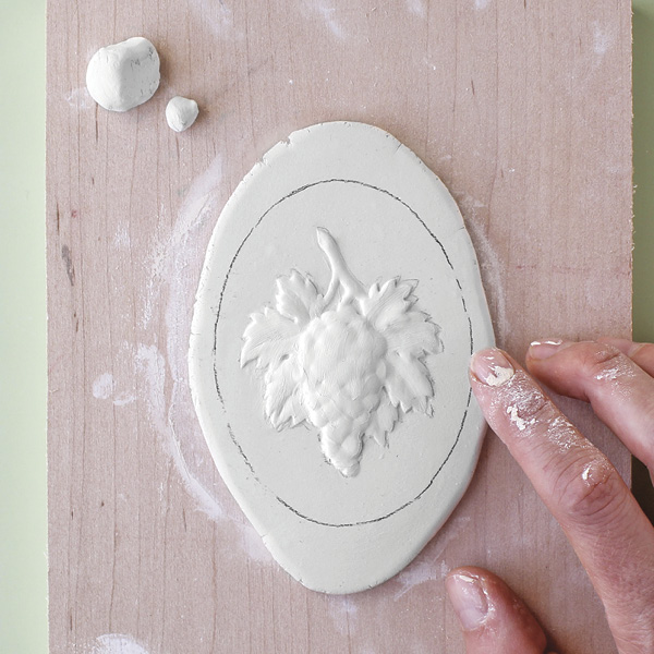 4 Build up the relief with bits of clay. Blend and smooth the form.