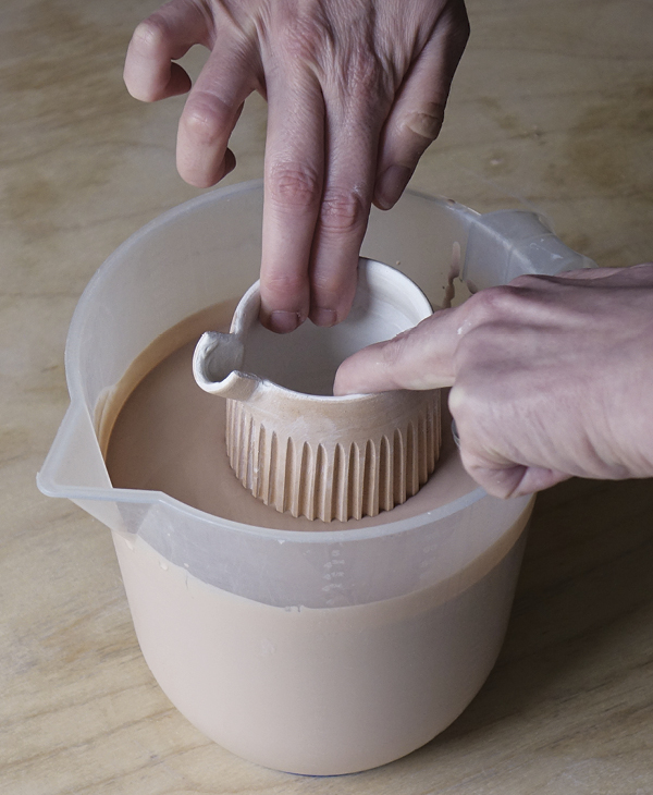 15 Using both hands, grip the rim from the interior, then dip the form in glaze to coat the exterior.