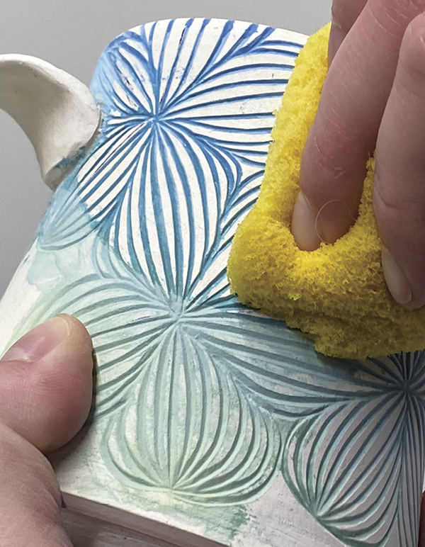 6 Remove the excess underglaze with a damp grout sponge.