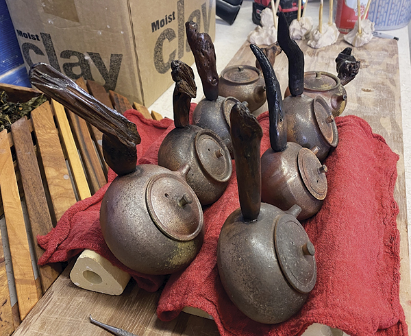 10 A batch of newly glued handles on fired Kyusu tea vessels, propped up to cure.