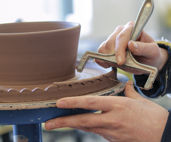 7 On a banding wheel, use a cheese cutter to scallop the plate edge.