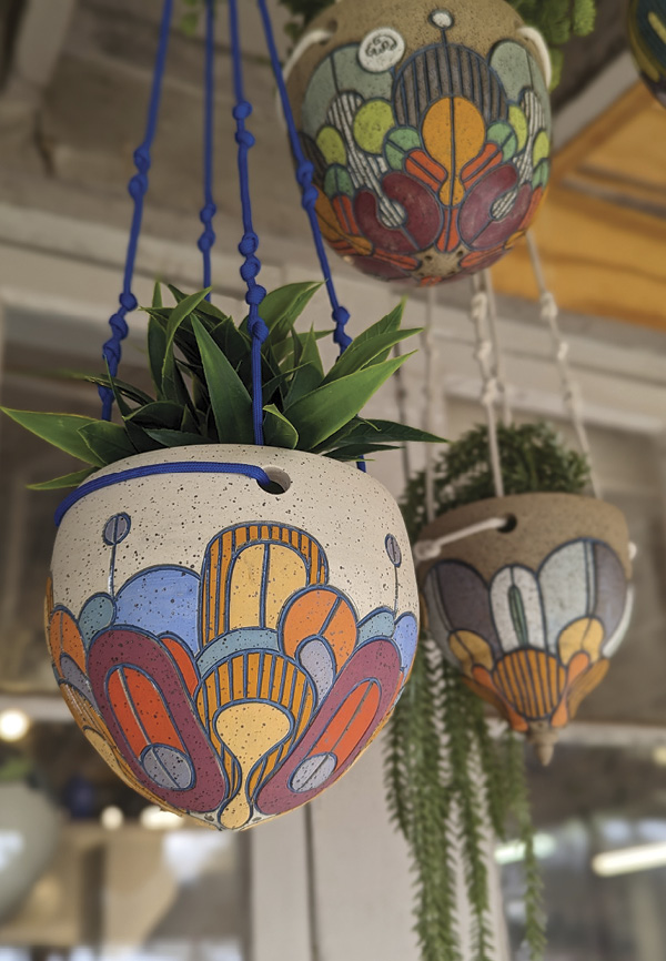 Image of colorfully decorated hanging ceramic planters by Round Trip Clayworks.