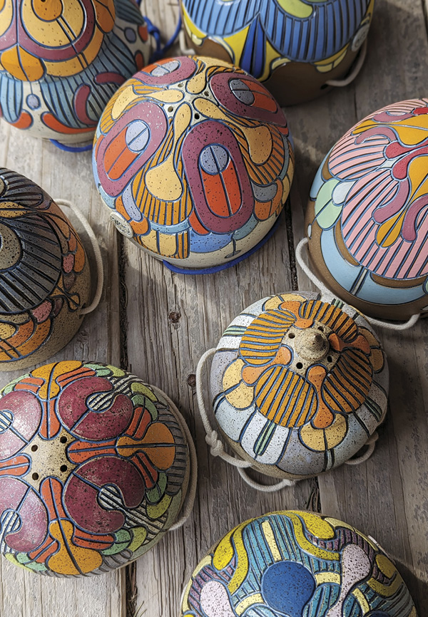 Image of colorfully decorated hanging ceramic planters by Round Trip Clayworks.