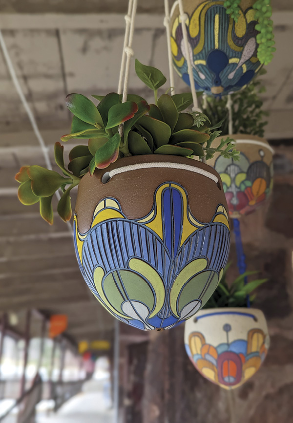 Image of colorfully decorated hanging ceramic planters by Round Trip Clayworks.