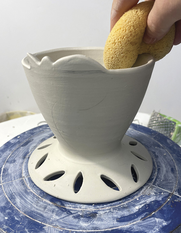 9 Use a damp sponge to compress and clean the rim and motif.